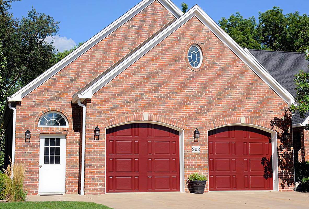 Brick house with two red garage doors